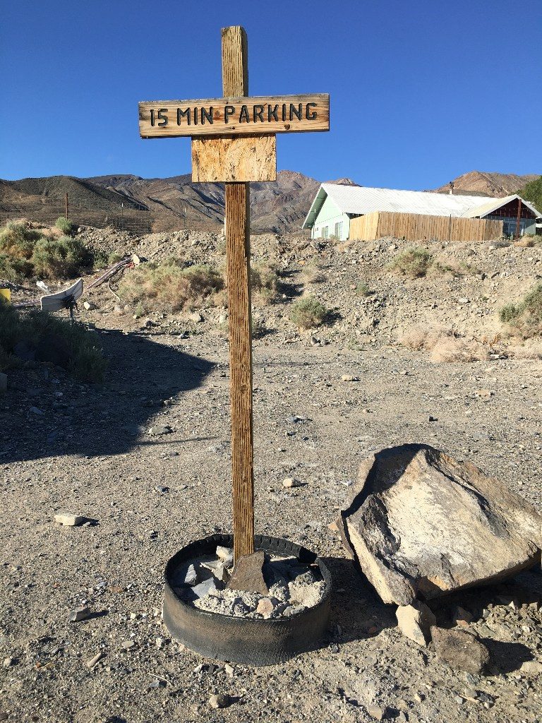 Photo of a funny sign in front of a remote residence near Death Valley California, reading - 15 minute parking
