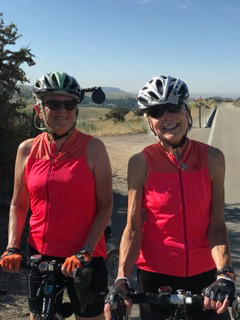 Bonnie V. with friend riding in hot weather in Bogus Basin Idaho, wearing matching red Hale Glow cycling tops from Terry Bicycles