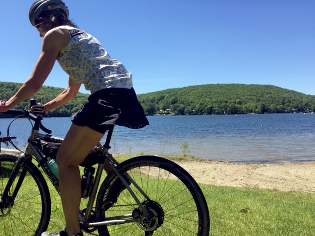 Photo of cyclist Jeannette wearing the Terry Rebel skort while riding past Lake St. Catherine in Vermont's Green Mountains