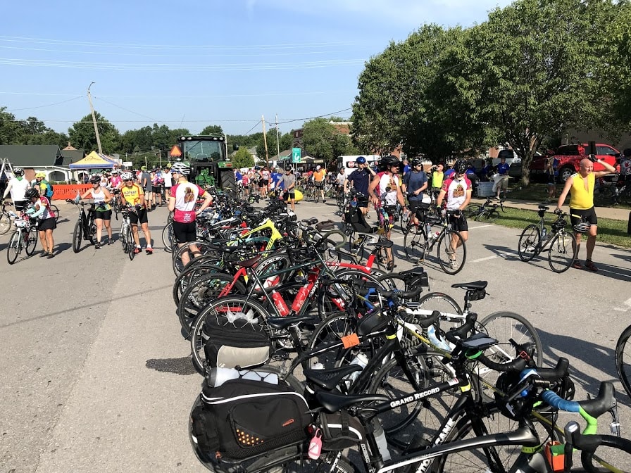 RAGBRAI 2019 - cyclists arriving in a pass through town in Iowa, hundreds of bicycles parked in the street