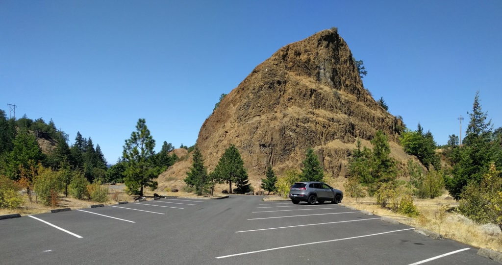 Photo of the trailhead of the Historic Columbia River Highway Trail, showing the nealy empty car park and a dramatic rock outcropping.