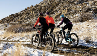 three female cyclists riding through a wintry landscape during a field test of women's cycling tights