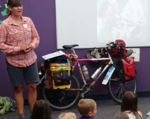 Sara with her fully laden touring bike giving a presentation to a kindergarten class.