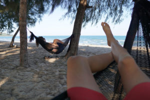 Pausing for a mid-day rest in hammocks on the beach, Baan Krud Thailand