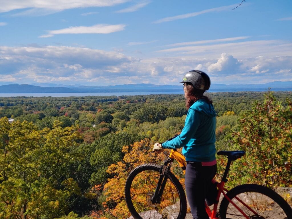 Pausing on a mountain bike ride in Vermont, looking across Lake Champlain toward New York's Adirondack Mountains.